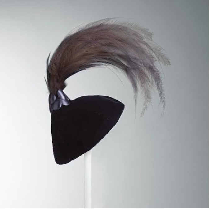 Sombrero de día 1950. El punto de unión del terciopelo y las plumas está cubierto con óvalos de plástico negro que imitan la madera de ébano.